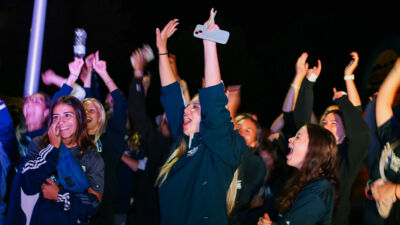 Students at an event at night cheering