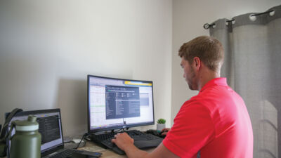 A graduate student working on a computer in their home office