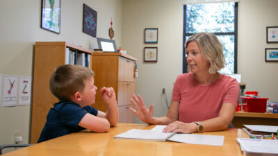 An education professor going through a workbook with a grade school student