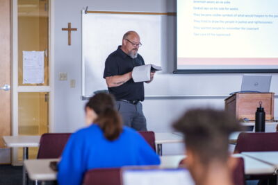 Professor reading a passage of the Bible in class.