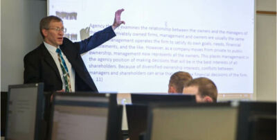 Business professor lecturing in front of a screen