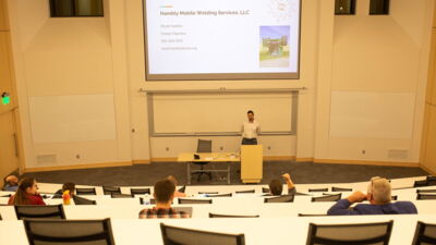 Guest presenting to a lecture hall of students about his business