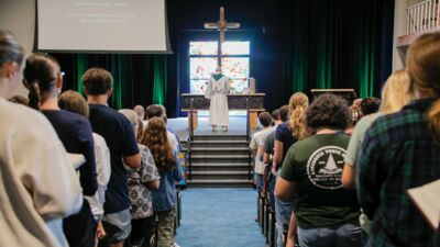 Pastor Matthias praying with a group of students