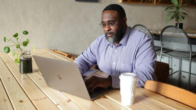 A graduate student studies on a laptop in a coffee shop