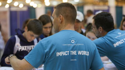 Staff members from Concordia handing out buttons at an LCMS Youth Gathering event