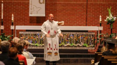 A pastor at the front of a church, addressing the congregation