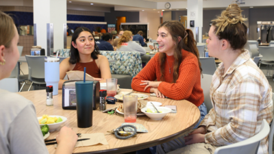 A group of students in Janzow Cafeteria eating a meal