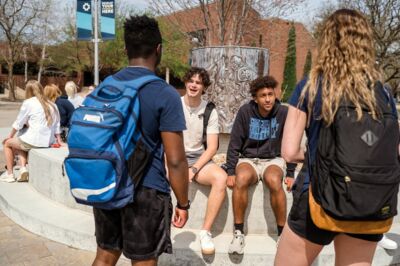 Students between classes, chatting at the center of the quad. 